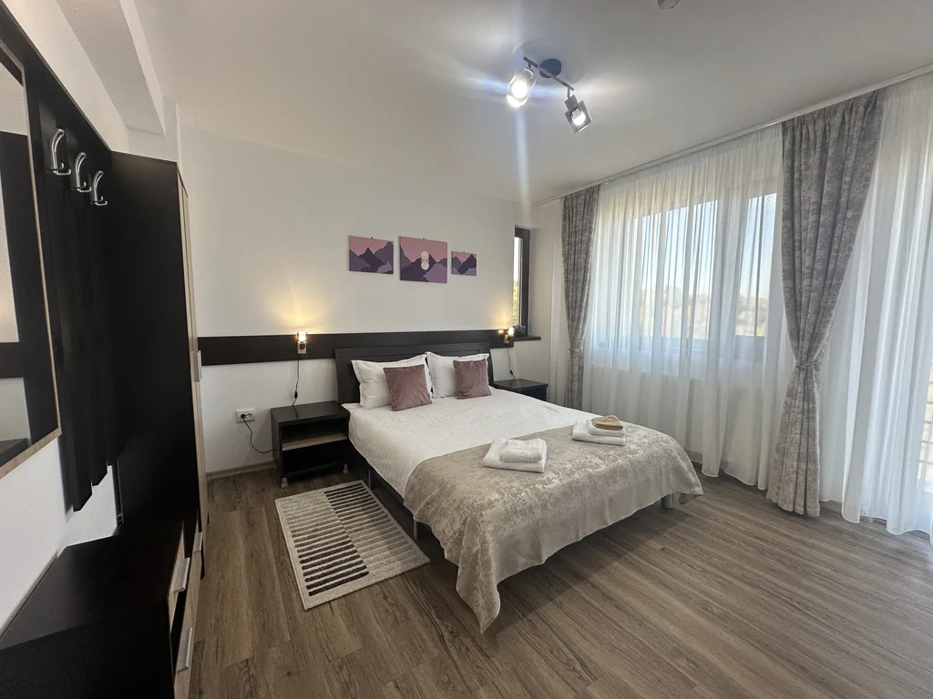 Camera 102 Casa Tilă: pat matrimonial, tablouri cu munți și ferestre spre balcon