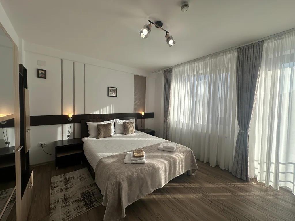 Camera 103 Casa Tilă: pat matrimonial, perete decorativ și ușă spre balcon