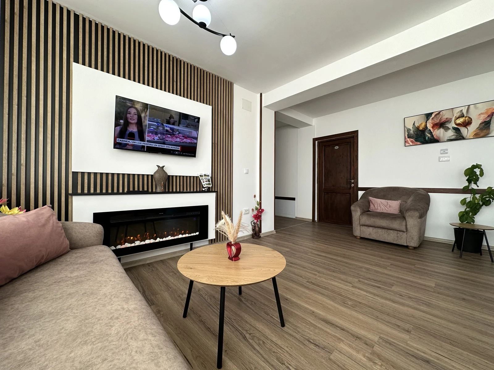 Living modern cu șemineu, canapea, fotoliu și TV la Casa Tilă Bran